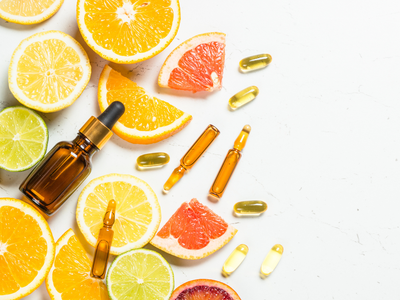 Vitamin C serum and citrus fruits with supplements on a white background – promoting natural immunity, antioxidant support, and skincare benefits. - Andyou.ph